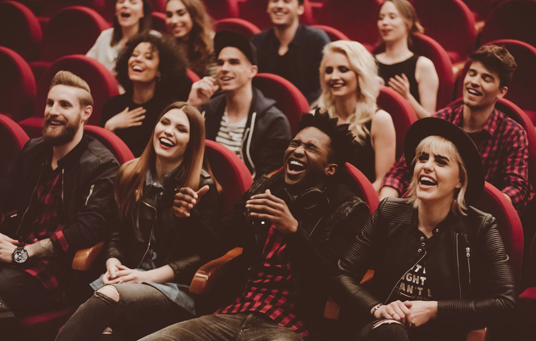 A cinema audience laughing during a screening