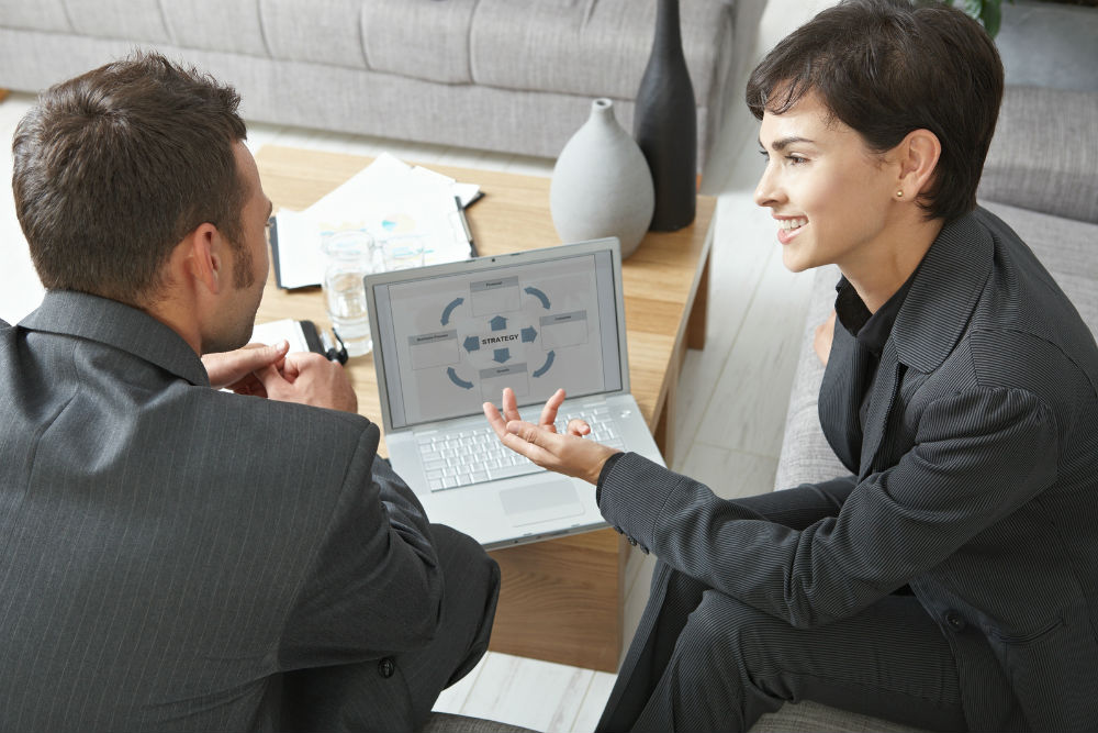 A sales conversation across a table with a laptop